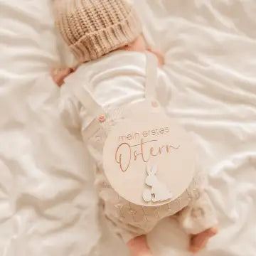 Eine weiche beige gestrickte Baby-Mütze mit einem subtilen Texturmuster.