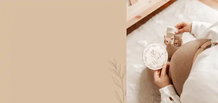 Weiße und goldene Baby-Rassel mit floralem Muster am Griff.